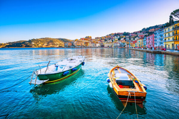Wooden small old boats in Porto Santo Stefano seafront, italian travel destination. Monte Argentario, Tuscany, Italy.